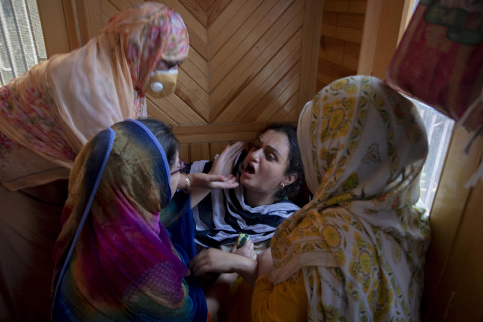 Relatives comfort the grieving daughter of civilian Bashir Ahmed Khan at their residence on the outskirts of Srinagar, Indian controlled Kashmir, Wednesday, July 1, 2020. Suspected rebels attacked paramilitary soldiers in the Indian portion of Kashmir, killing Khan and a paramilitary soldier, according to government sources. The family refutes the claim. (AP Photo/ Dar Yasin)