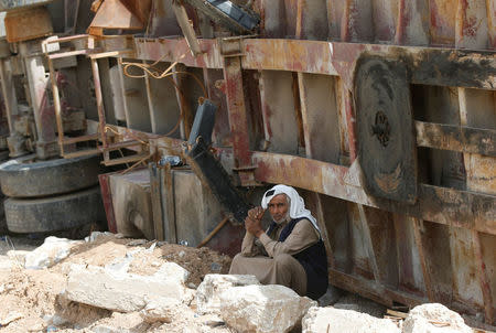 A displaced Iraqi man sits near a broken truck as he flees after a battle between the Iraqi Counter Terrorism Service and Islamic State militants in western Mosul, Iraq, April 22, 2017. REUTERS/Muhammad Hamed