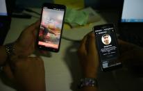 Employees of Indian tech company Frankly.me use phones to test their app at an office in Noida on the outskirts of New Delhi on June 30, 2015