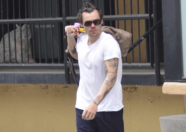 Harry Styles covers up with a mask, hoodie and shades during