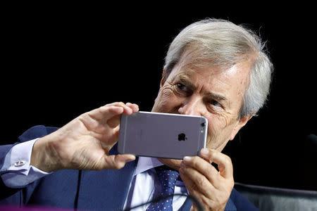 Vincent Bollore, Chairman of the Supervisory Board of media group Vivendi, takes pictures with his mobile phone while attending the company's shareholders meeting in Paris, France, April 19, 2018. REUTERS/Charles Platiau