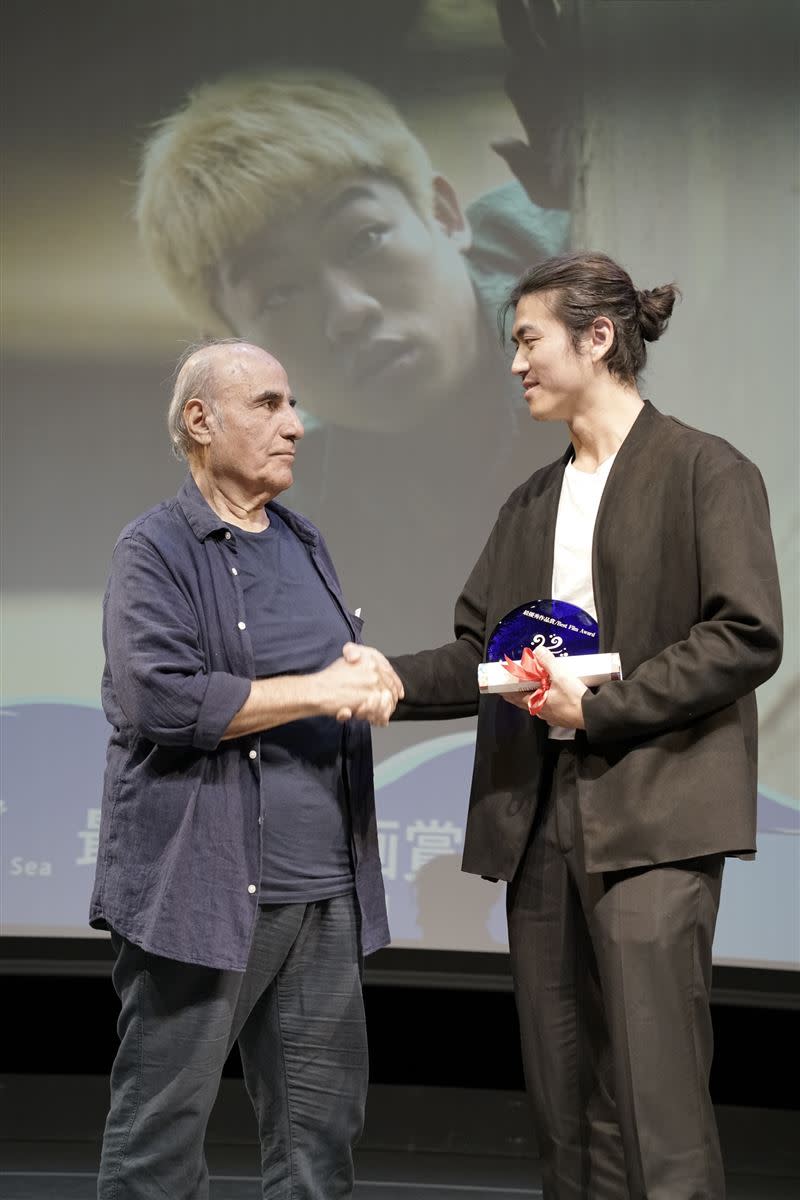 主席Amir Naderi頒獎給鍾侑霖導演。（圖／沖繩環太平洋國際電影節提供）