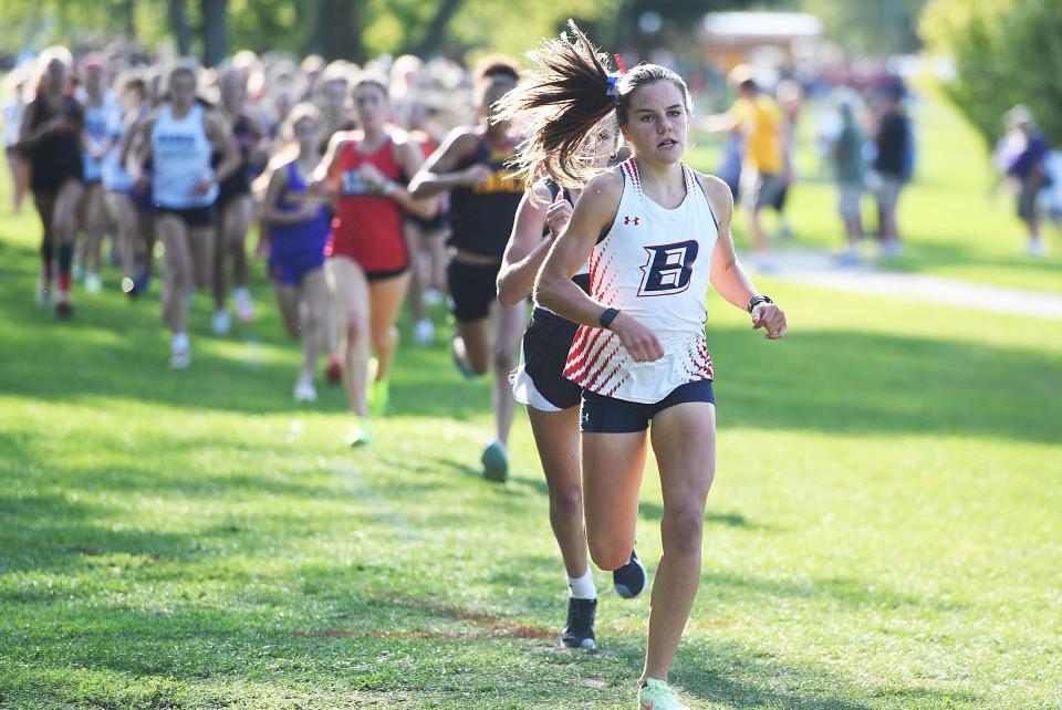 Ballard's Paityn Noe takes the lead during the varsity girls race at the Mike Carr Invitational cross country meet at the Ballard Golf and Country Club on Sept. 12 in Huxley.