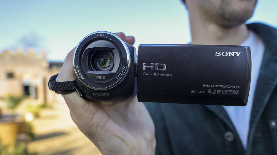 A man holding the Sony HDR-CX405 camcorder