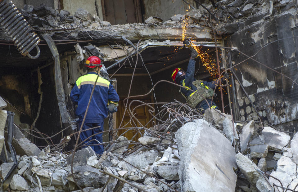 Ukrainian emergency service personnel work outside the damaged building following shelling, in Kharkiv, Ukraine, Saturday, June 4, 2022. (AP Photo/Sofiia Bobok)