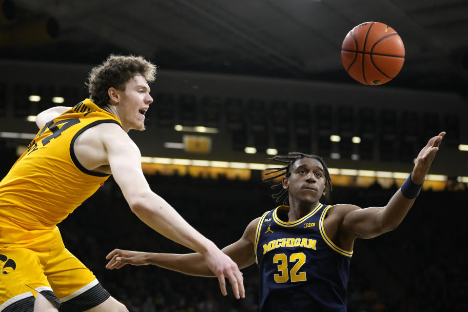 Iowa forward Riley Mulvey, left, fights for a rebound with Michigan forward Tarris Reed Jr. (32) during the second half of an NCAA college basketball game, Thursday, Jan. 12, 2023, in Iowa City, Iowa. (AP Photo/Charlie Neibergall)