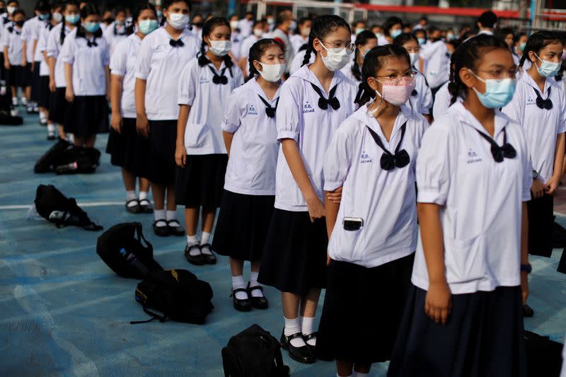 Girls wearing masks to prevent the spread of the coronavirus disease (COVID-19) line up at the schoolyard before the start of their lesson day in Bangkok