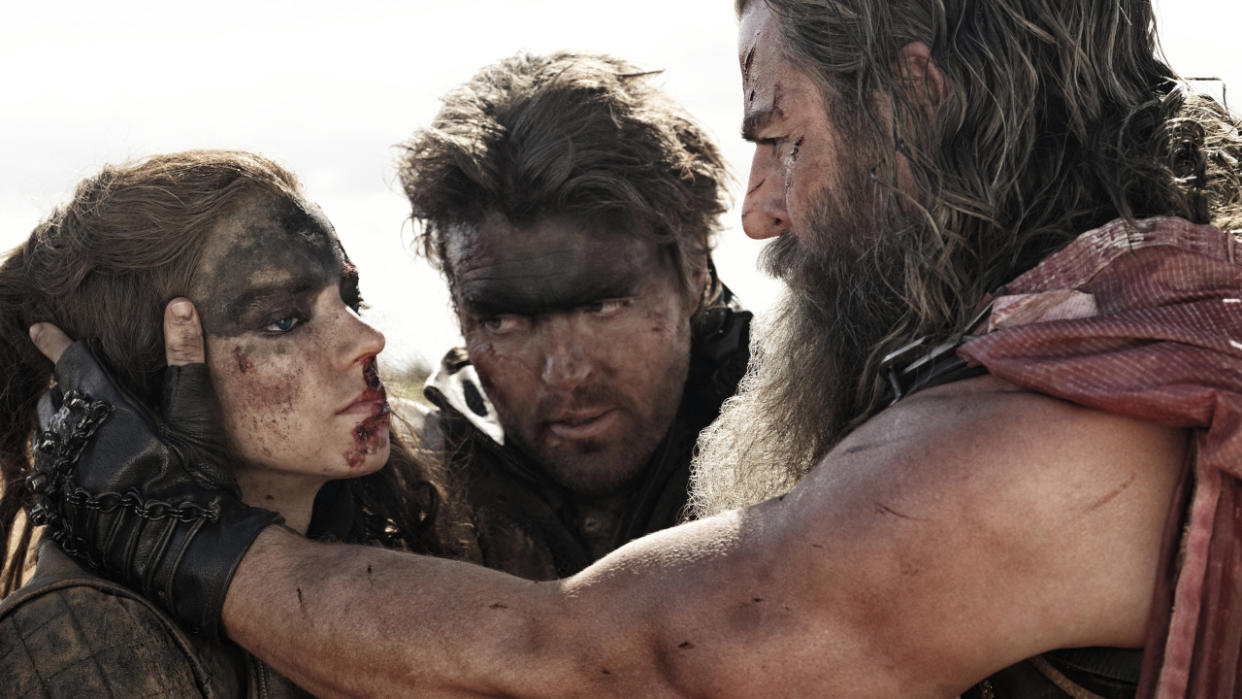  Chris Hemsworth holds a bloodied Anya Taylor-Joy's head in his hands as Tom Burke watches in Furiosa: A Mad Max Saga. 