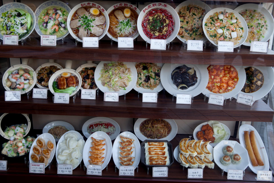 Plates of fake food in a restaurant window.