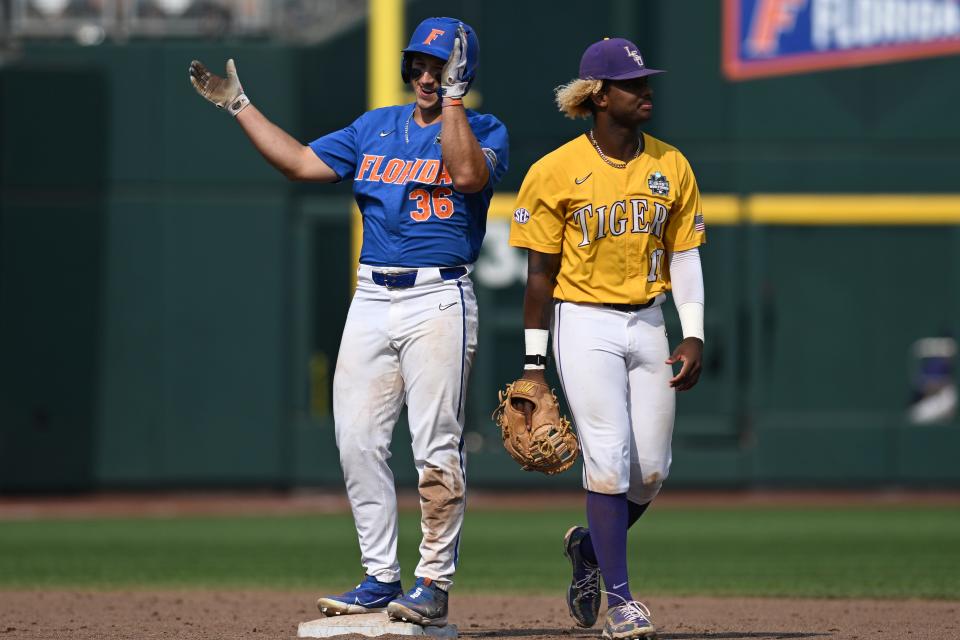 Florida center fielder Wyatt Langford (36) celebrates hitting a double as LSU infielder Tre' Morgan (18) waits for the throw during Game of the College World Series championship series.