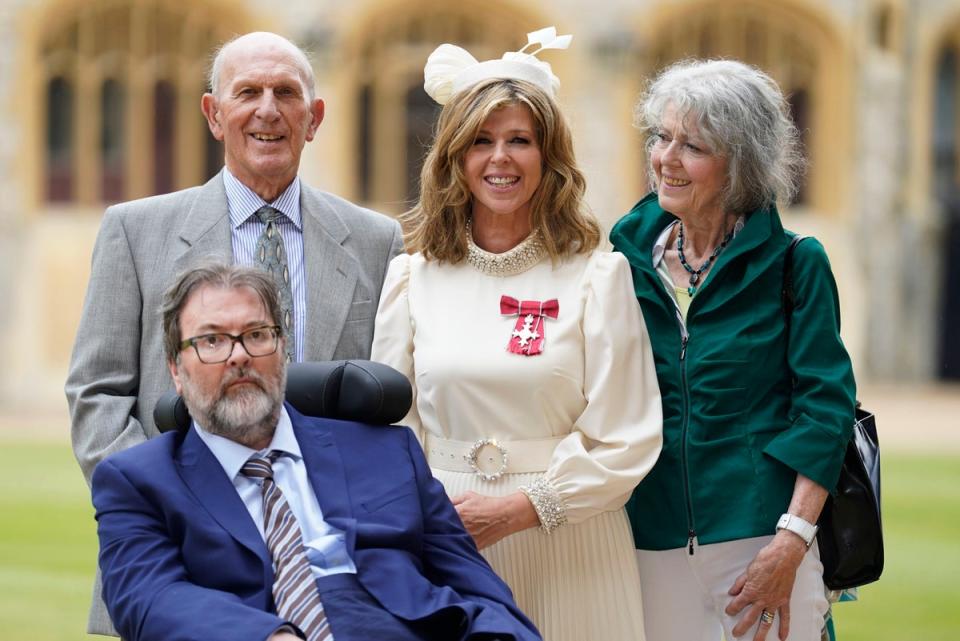 Kate Garraway, with her husband Derek Draper and her parents Gordon and Marilyn Garraway, after being made an MBE (AP)