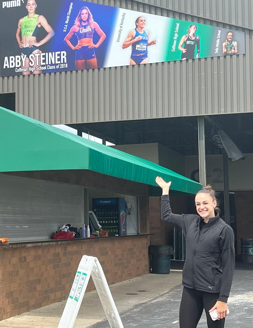 Dublin Coffman graduate Abby Steiner points out the mural that was unveiled Saturday at the school to commemorate her running career.