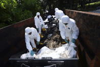 Workers load bags of oil-stained sands at Sentosa's Tanjong Beach area in Singapore, Sunday, June 16, 2024. (AP Photo/Suhaimi Abdullah)