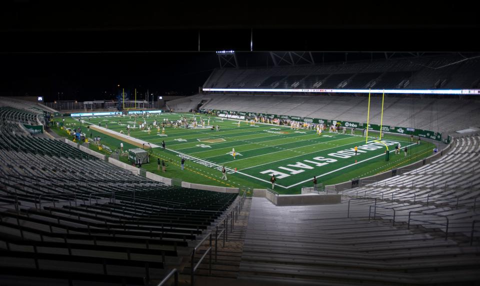 The Colorado State Rams and the Wyoming Cowboys warm up in front of an empty stadium before the game at Colorado State University's Canvas Stadium.