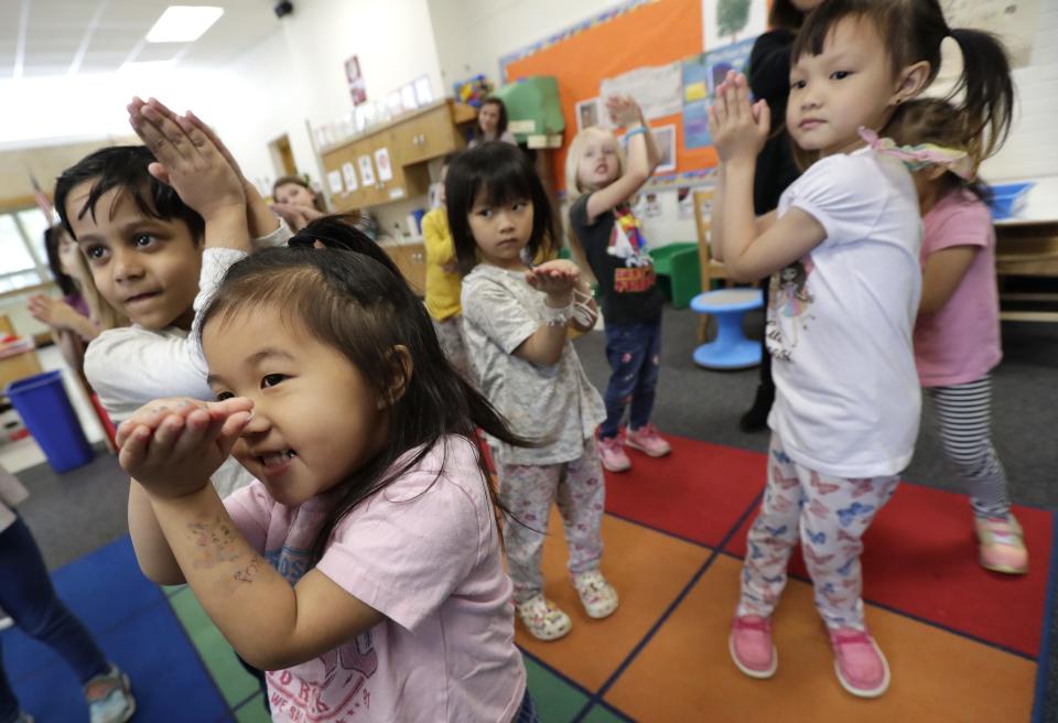 Layla Her, bottom left, participates in a movement activity to help language skills and following directions during her 4K class at Foster Elementary School in Appleton.