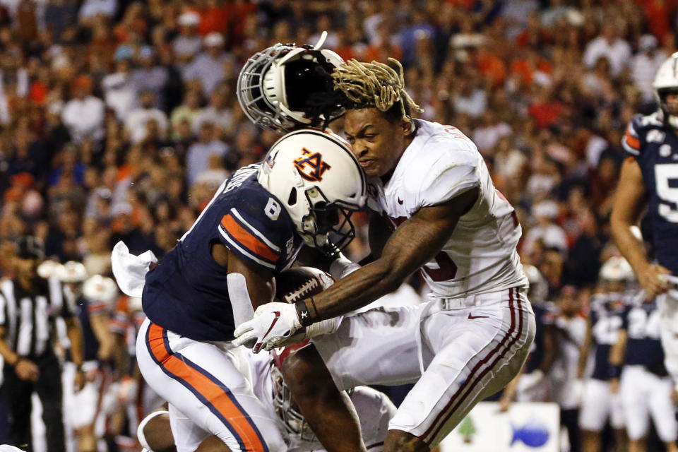 Alabama defensive back Xavier McKinney (15) loses his helmet as Auburn running back Shaun Shivers (8) runs through him for a touchdown during the second half of an NCAA college football game Saturday, Nov. 30, 2019, in Auburn, Ala. (AP Photo/Butch Dill)