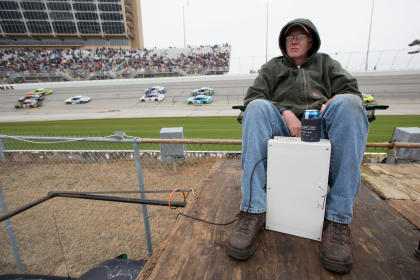 Mar 1, 2015; Hampton, GA, USA; Sitting with a electrical heater and a beer, Bennie Waller of Milledgeville, Ga., watches the Folds of Honor QuikTrip 50 from the infield at Atlanta Motor Speedway. (Kevin Liles-USA TODAY Sports)