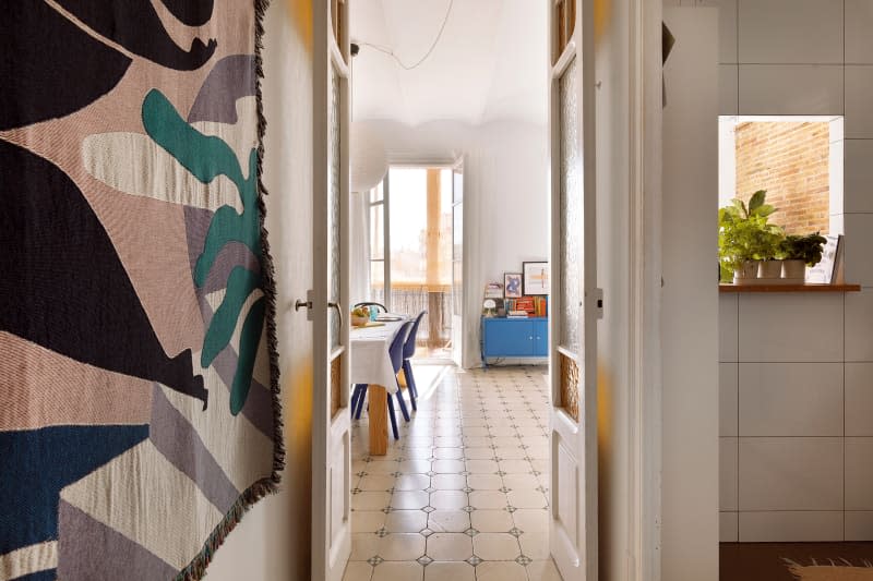 Hallways with tile floors leading to the kitchen and living area.