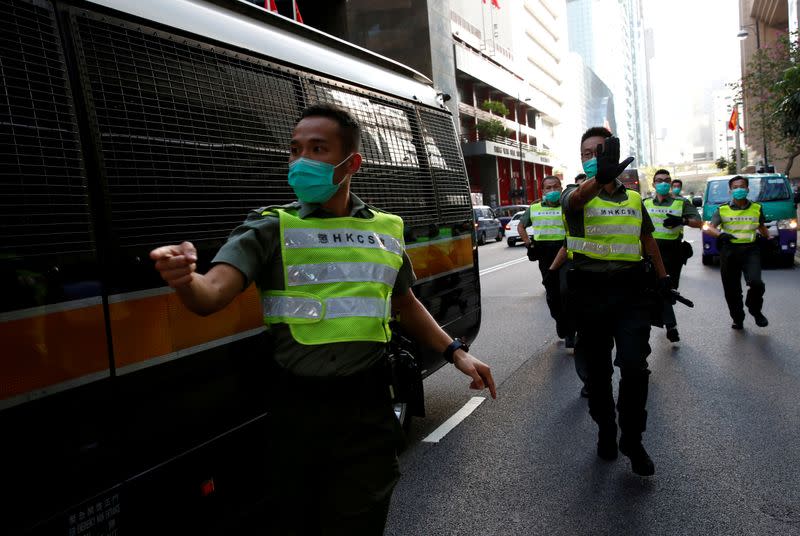 FILE PHOTO: Staff of Correctional Services Department (CSD) escort a prison van after an anti-government protester Sin Ka-ho has been sentenced four years for rioting, in Hong Kong, China