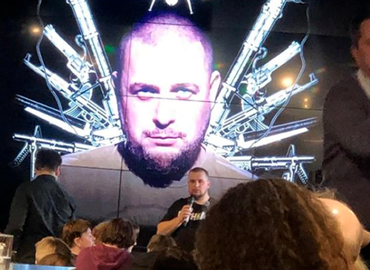 Vladlen Tatarsky speaks in front of a projected image of himself.