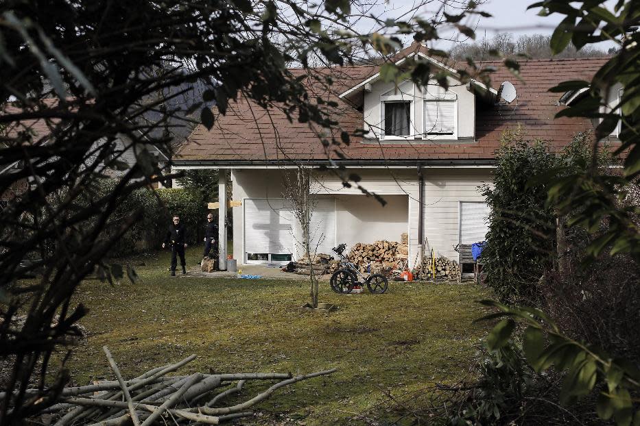 French police stand outside a house in a residential area in Talloires, French Alps, Tuesday, Feb. 18, 2014, as part of the continuing investigation into the grisly shooting deaths of a British-Iraqi man and three others nearly 18-months ago. French police announced Tuesday they have detained a 48-year old man, a resident of eastern France, in connection with the deaths. (AP Photo)