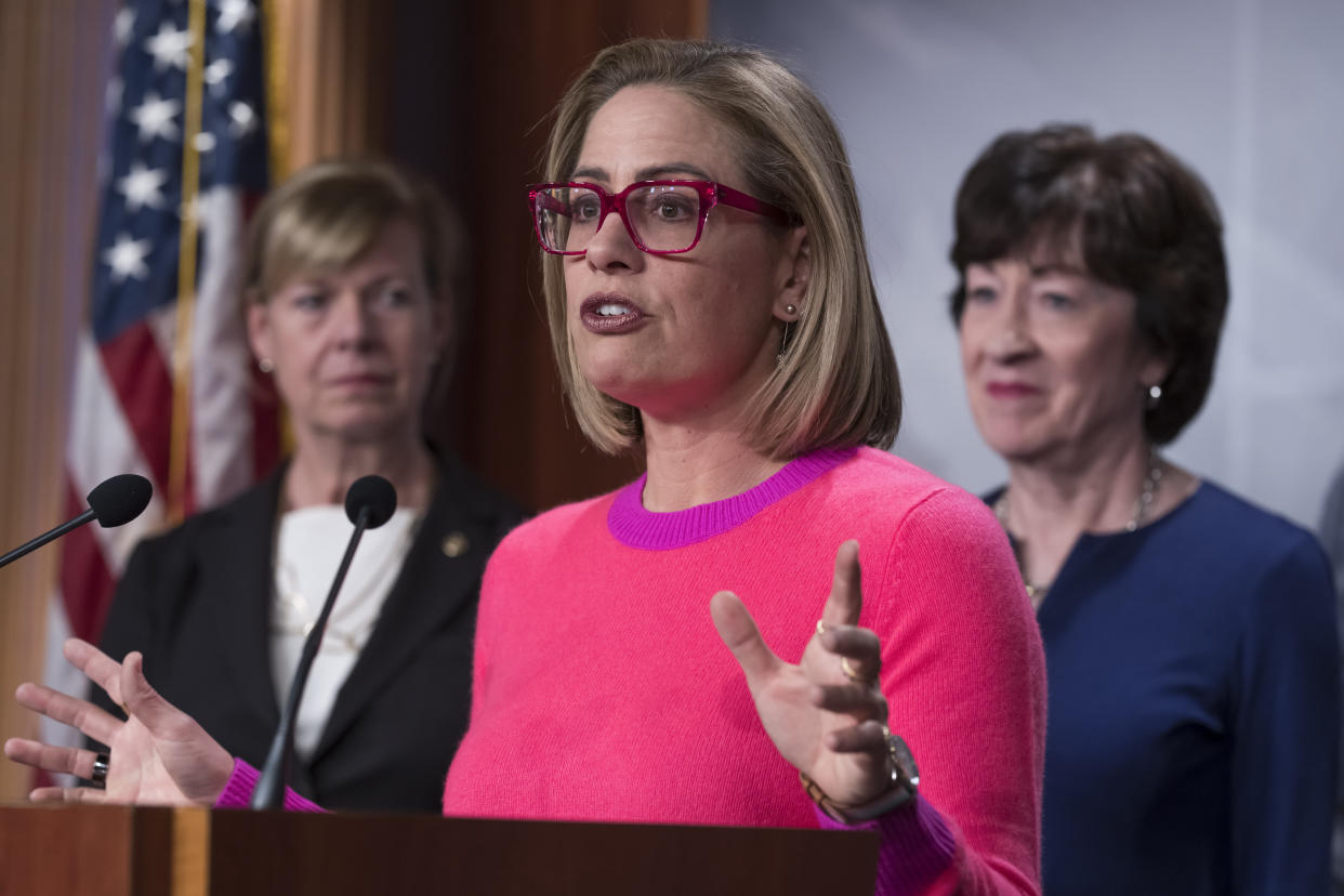 Sen. Kyrsten Sinema, D-Ariz., flanked by Sen. Tammy Baldwin, D-Wis., left, and Sen. Susan Collins, R-Maine.