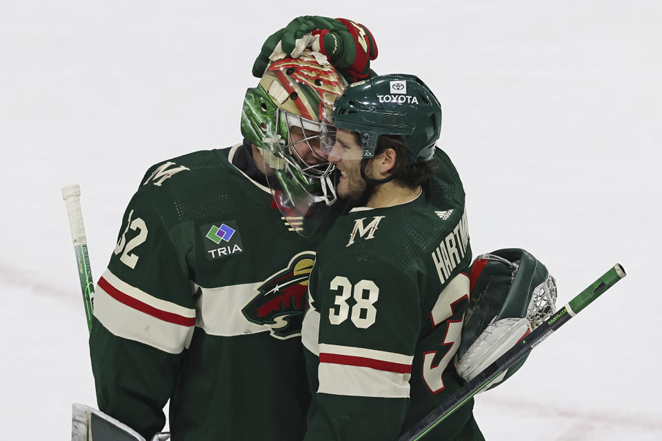 Minnesota Wild right wing Ryan Hartman (38) celebrates with goaltender Filip Gustavsson (32) after the team's 5-1 over the Dallas Stars in Game 3 of an NHL hockey Stanley Cup first-round playoff series Friday, April 21, 2023, in St. Paul, Minn. (AP Photo/Stacy Bengs)