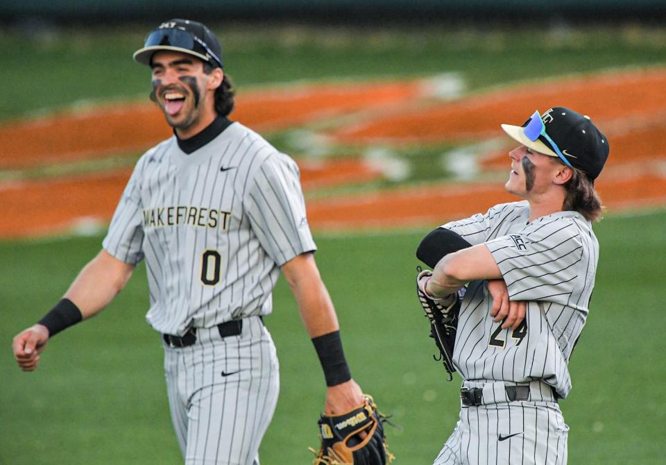 Wake Forest sophomore Tommy Hawke (24) reacts after pulling a home run ball back inside the field for an out after Clemson senior Riley Bertram (6) hit it to him, with Wake Forest junior Lucas Costello (0) reacts near him, during the bottom of the third inning at Doug Kingsmore Stadium in Clemson Thursday, March 30, 2023.