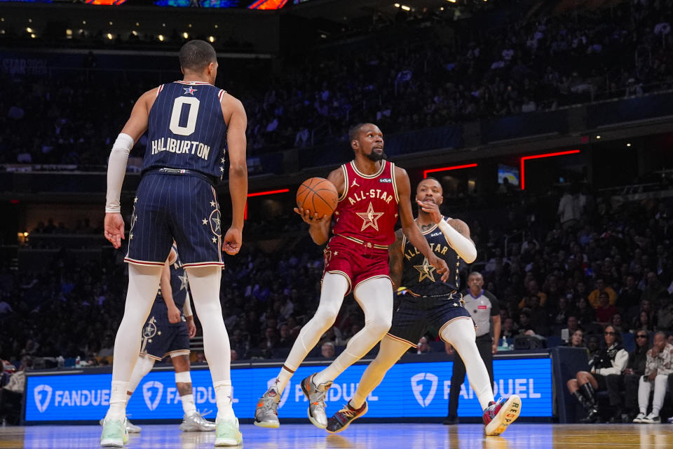 Phoenix Suns forward Kevin Durant (35) drives on Milwaukee Bucks guard Damian Lillard (0) during the first half of an NBA All-Star basketball game in Indianapolis, Sunday, Feb. 18, 2024. (AP Photo/Darron Cummings)