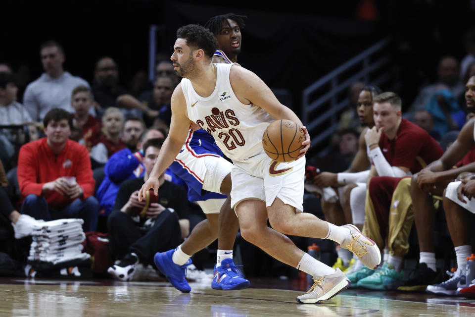 Cleveland Cavaliers forward Georges Niang (20) drives against Philadelphia 76ers guard Tyrese Maxey during the first half of an NBA basketball game Friday, March 29, 2024, in Cleveland. (AP Photo/Ron Schwane)