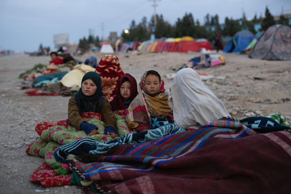 FILE - Afghan children are covered with a blanket as their families camp outside the Directorate of Disaster, in Herat, Afghanistan, Monday, Nov. 29, 2021. Pakistan is rallying Muslim countries to help Afghanistan stave off an economic and humanitarian disaster while also cajoling the neighboring country's new Taliban rulers into concessions to soften their image abroad. (AP Photo/Petros Giannakouris, File)