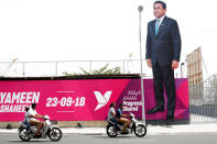 People ride motorcycles past an image of Maldives President Abdulla Yameen on a road ahead of the presidential election in Male, Maldives September 19, 2018. REUTERS/Ashwa Faheem