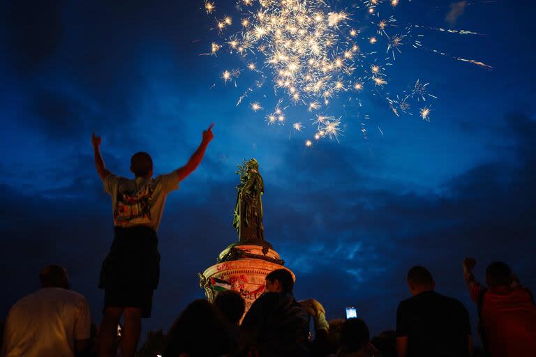 La gente se reúne frente a la estatua 