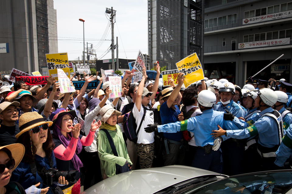 Anti-racist groups (L) try to block Japanese nationalists from marching on the street during a rally demanding an end to hate speech in Kawasaki, Japan, on July 16, 2017. Scuffles erupted when right-wing activists marched with their slogans, flags, and racist speech, forcing police to intervene.<span class="copyright">Richard Atrero de Guzman—NurPhoto/Getty Images</span>