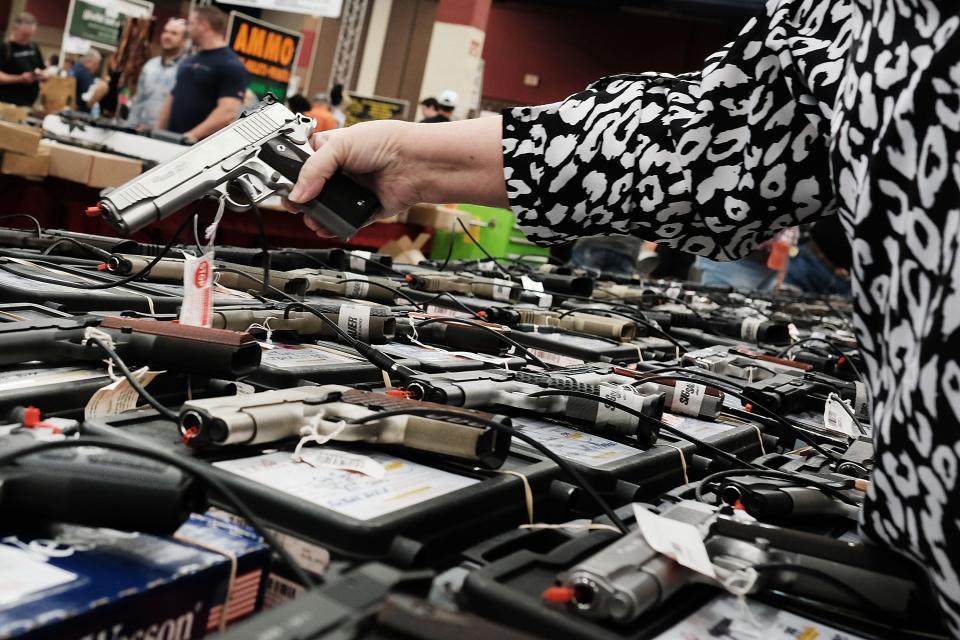 A woman tries a pistol at a 2016 gun show in Fort Worth, Texas. Federal officials say many gun sellers have avoided the rules requiring background checks, allowing more guns onto the black market.