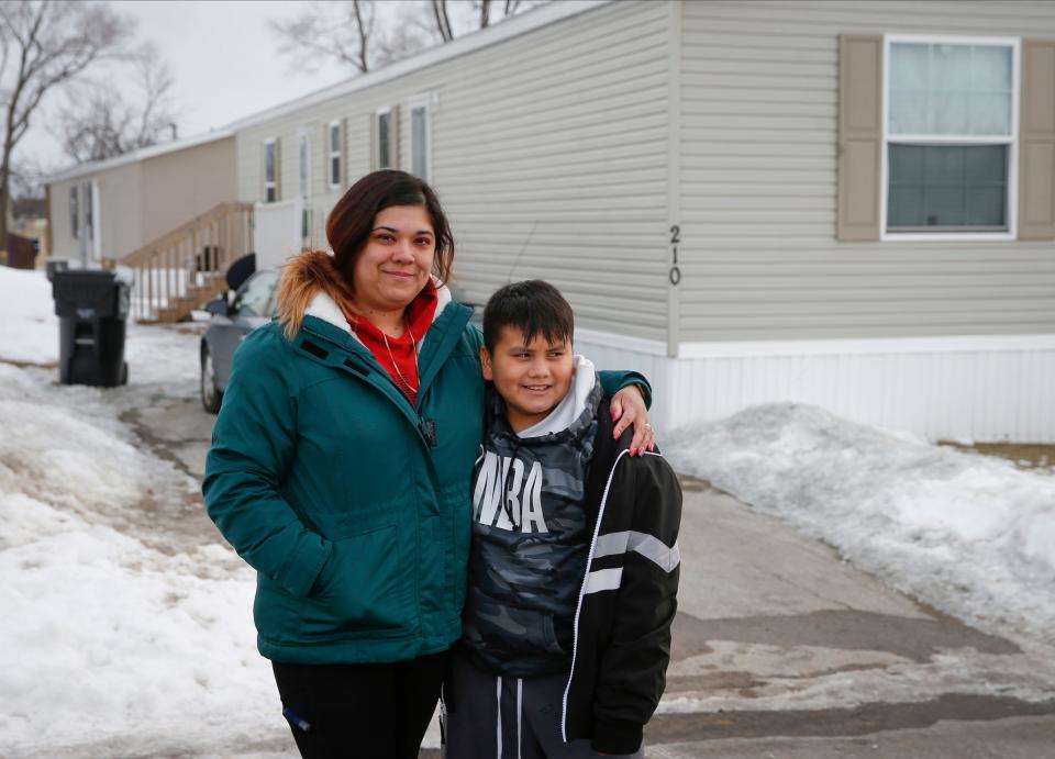 Christine Rodriguez and her 11-year-old son, Oscar Rodriguez, Jr., stand outside of the mobile home they currently live in outside of Des Moines, Iowa, on Sunday, Feb. 1, 2022.