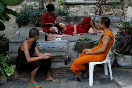 Nat (2nd L) combs a friend's hair during their stay at Wat Thamkrabok monastery in Saraburi province, Thailand, February 3, 2017. REUTERS/Jorge Silva