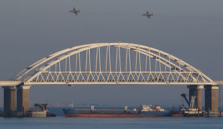 Russian jet fighters fly over a bridge connecting the Russian mainland with the Crimean Peninsula with a cargo ship beneath it after three Ukrainian navy vessels was stopped by Russia from entering the Sea of Azov via the Kerch Strait in the Black Sea, Crimea November 25, 2018. REUTERS/Pavlishak Alexey