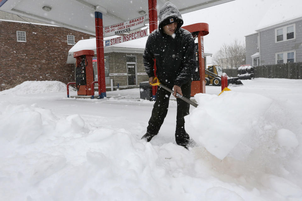 Andrew Pyliotis, of Wrentham, Mass., shovels snow in front of his gas station in Norwood, Mass., Wednesday, Feb. 5, 2014. Six to 12 inches of snow is expected around Boston, with 3 to 6 inches in southeastern areas before changing to sleet and rain. (AP Photo/Steven Senne)