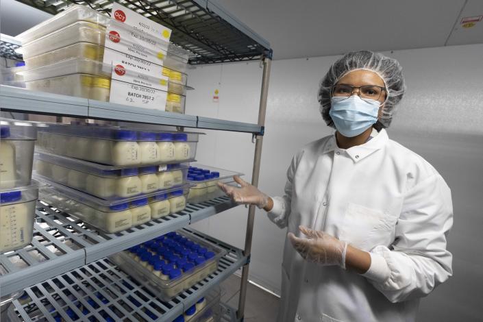 Lab manager Shantel Collins stands in the freezer next to a shelf of pasteurized breast milk at Mothers' Milk Bank of the Northeast, Friday, May 13, 2022, in Newton, Mass. (AP Photo/Michael Dwyer)
