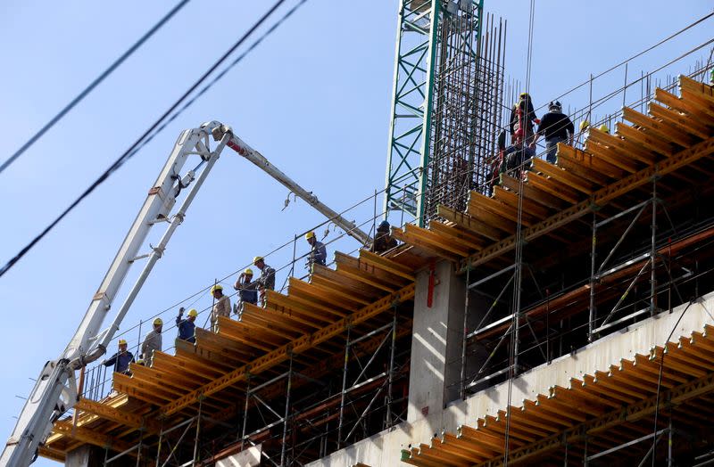 Workers work at a construction site to build an office building and shopping mall in a residential area in Buenos Aires