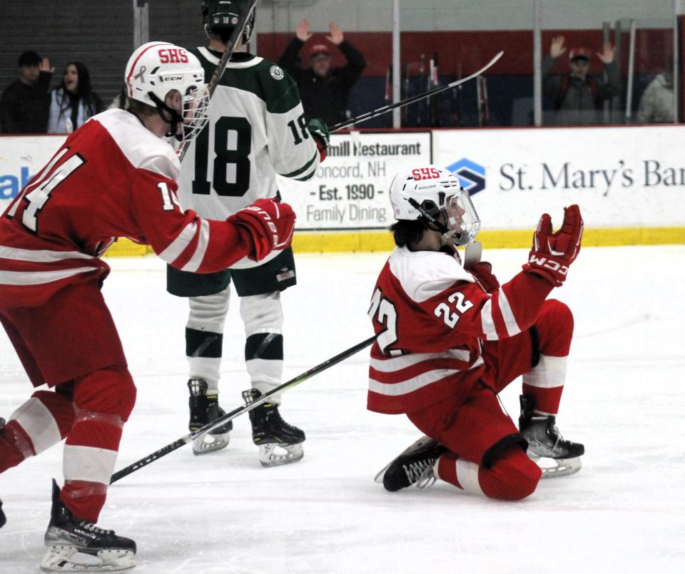 Spaulding's Ryan Dube (right) celebrates what turned out to be the game-winning goal in the Red Raiders' semifinal win over Dover on Wednesday, March 6, 2024 at Everett Arena in Concord.. Teammate Trevor Brennan (14) looks to join him as Dover's Owen Culcasi (18) skates away.