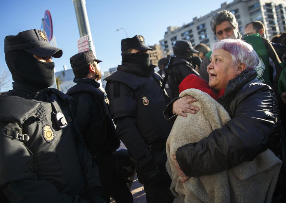 An anti-eviction activist argues with riot police as she holds one-month-old son Dilan after his family was evicted from their apartment in Madrid,
