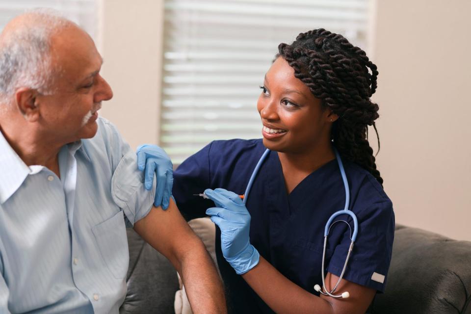 A healthcare worker vaccinates a person in a medical office.