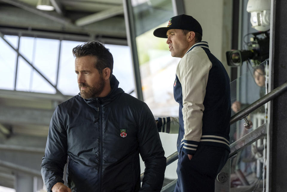 This image released by FX shows Rob McElhenney, Ryan Reynolds, right, in a scene from the second season of "Welcome to Wrexham." premiering Sept. 12. (FX via AP)