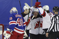 New Jersey Devils' Jack Hughes, middle rear, celebrates after a second-period goal against New York Rangers' Alexandar Georgiev, left, in an NHL hockey game Tuesday, Jan. 19, 2021, in New York. (Bruce Bennett/Pool Photo via AP)