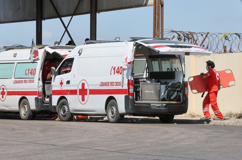 A member of the Lebanese Red Cross holds a stretcher as he waits with his colleagues to receive dead bodies after sinking of a migrant boat