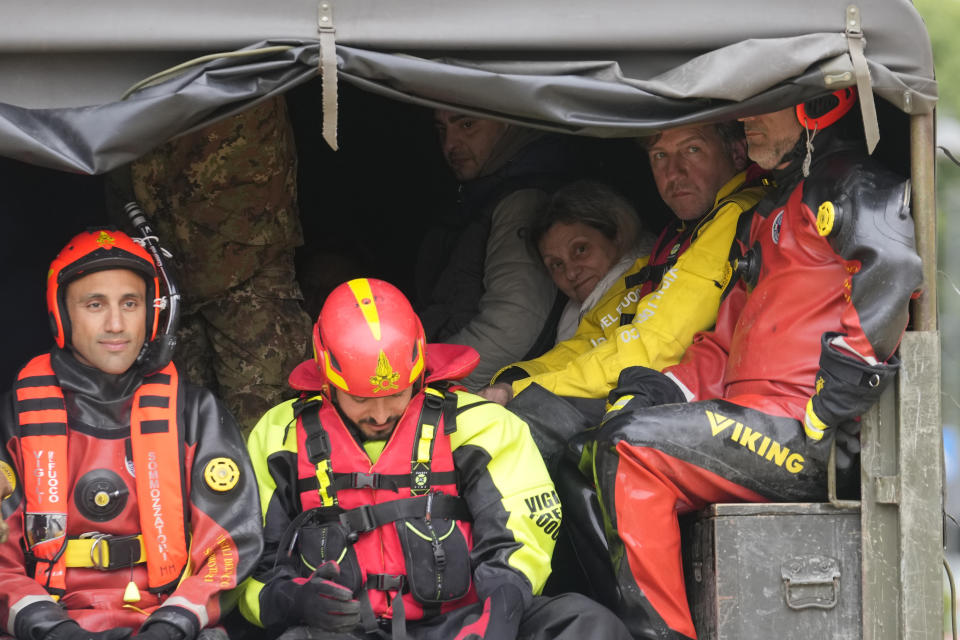 People are on a truck after being rescued by firefighters in the village of Castel Bolognese, Italy, Wednesday, May 17, 2023. Exceptional rains Wednesday in a drought-struck region of northern Italy swelled rivers over their banks, killing at least eight people, forcing the evacuation of thousands and prompting officials to warn that Italy needs a national plan to combat climate change-induced flooding. (AP Photo/Luca Bruno)