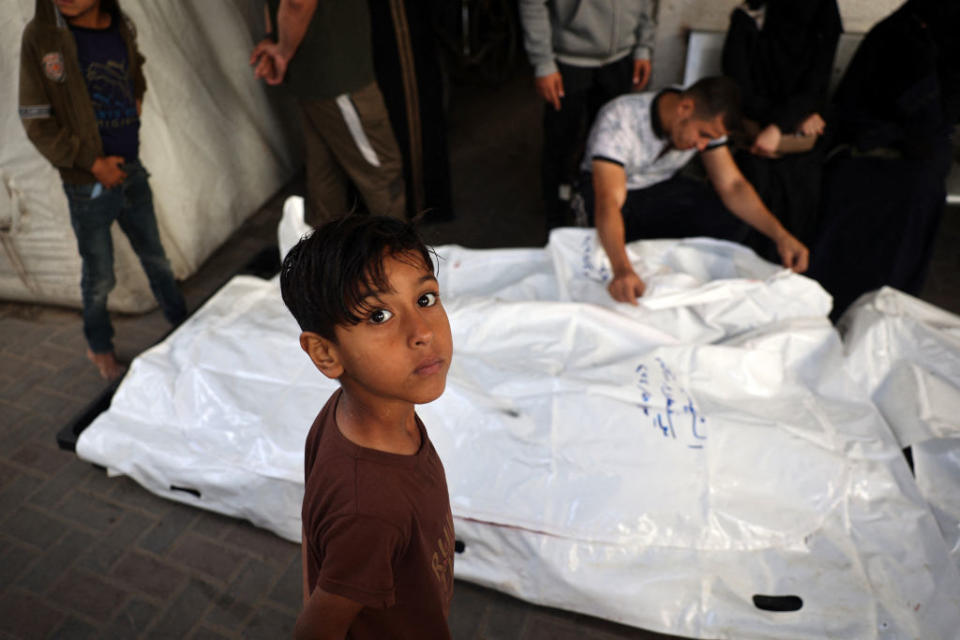 A young boy looks on as relatives of Palestinians killed in Israeli bombing mourn near their corpses in the yard of the Al-Najjar Hospital in Rafah in on May 3, 2024.<span class="copyright">AFP—Getty Images</span>