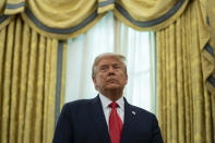 President Donald Trump listens during a ceremony to present the Presidential Medal of Freedom to former football coach Lou Holtz, in the Oval Office of the White House, Thursday, Dec. 3, 2020, in Washington. (AP Photo/Evan Vucci)